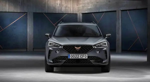 Szary SUV z charakterystycznym logo na grillu. To Cupra, jaka to marka? Sportowy design i nowoczesne linie.