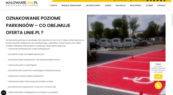 Malowanie oznaczenie miejsca dla niepełnosprawnych na czerwonym tle parkingu. W tle białe busy i drzewa.