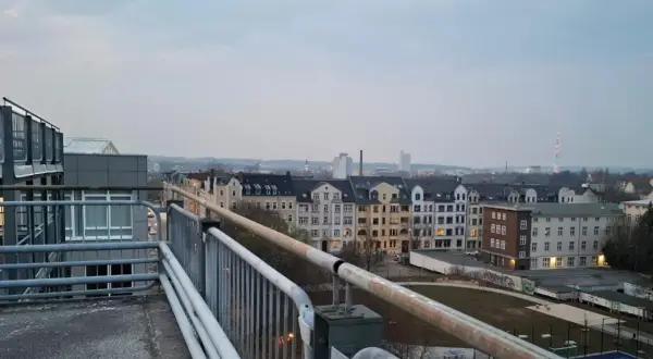 Blick über Chemnitz mit alten Häusern und einem bunten Turm im Hintergrund. Hier gibt es viele Geheimtipps zu entdecken.