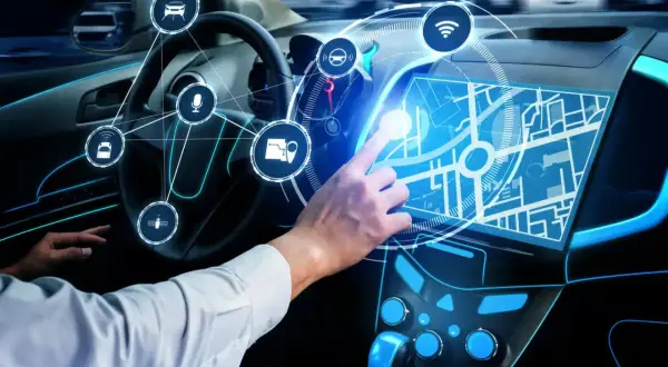 Ręka Adama dotyka ekranu nawigacji w samochodzie przyszłości. Ikony symbolizują funkcje smart car.