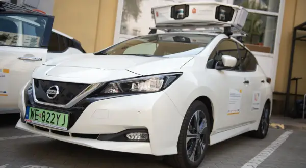 Biały samochód Nissan z zamontowanym na dachu urządzeniem do skanowania.