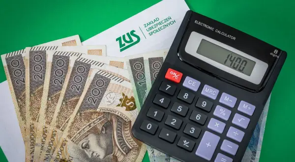 ZUS, banknoty 200 zł i kalkulator pokazują podstawę wymiaru składki na ubezpieczenie emerytalno-rentowe.