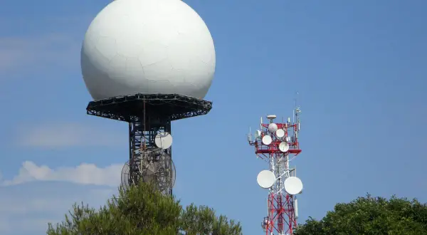 Duża biała kopuła, prawdopodobnie najlepszy radar pogodowy, góruje nad wieżą telekomunikacyjną.
