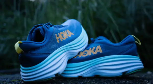 Chaussures de course Hoka bleues avec semelles épaisses et ondulées, offrant le meilleur amorti pour vos foulées.