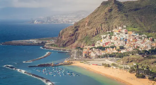 Kolorowe domki na zboczu góry nad plażą z łódkami. Czy to Teneryfa czy Fuerteventura?
