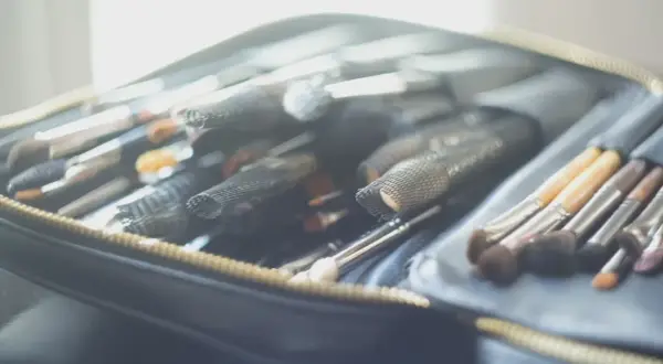 Une trousse ouverte révèle une collection de pinceaux de maquillage, prêts pour un cours de maquillage particulier.