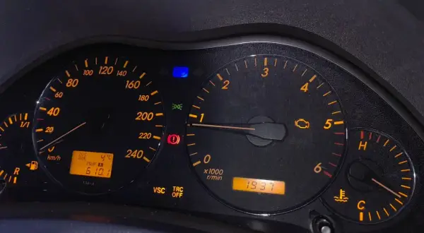 Kontrolka silnika świeci się, wskazując błąd DTC C1201 Toyota. Na desce rozdzielczej widoczne są też inne kontrolki i wskaźniki.