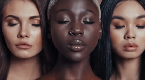 Three women of different ethnicities with eyes closed and makeup on.