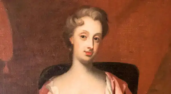 Porträtt av Christina Piper i rosa klänning, med en mjuk blick och uppsatt hår.