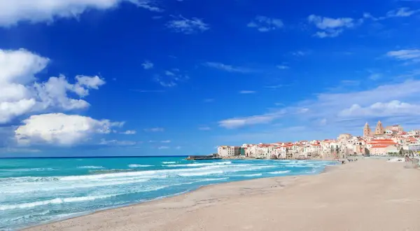 Le spiagge di Cefalù, con la loro sabbia dorata e il mare azzurro, invitano a rilassarsi sotto il sole siciliano.