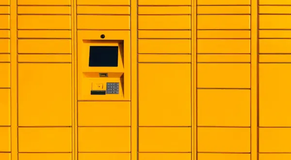 Żółty paczkomat InPost z ekranem dotykowym i klawiaturą numeryczną.