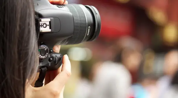 A person's hands hold a Canon digital camera, ready to capture a moment. This image is a great visual for anyone learning how to buy a digital camera.