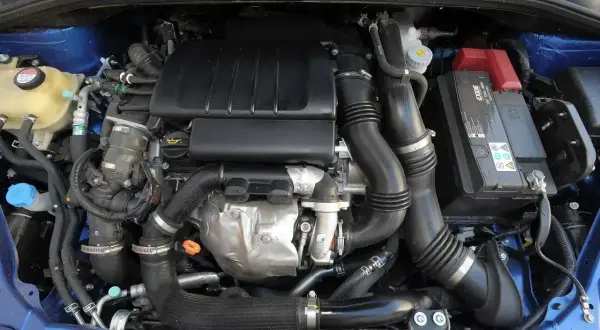 Silnik samochodowy Suzuki SX4 z widocznymi przewodami, akumulatorem i elementami układu dolotowego.