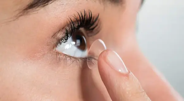 Zbliżenie na oko, na które zakładana jest soczewka. Czy każdy może nosić soczewki? Konsultacja z optometrystą jest kluczowa.