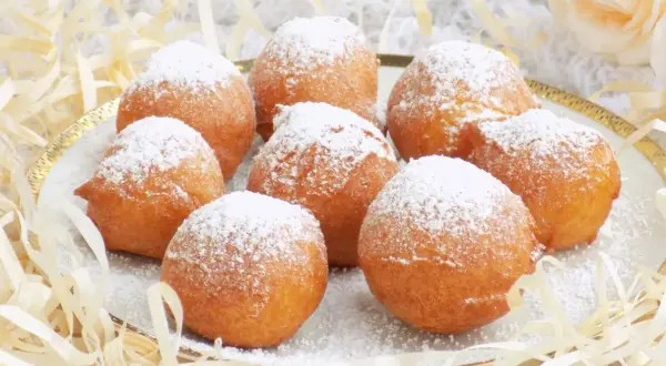 Puszyste paczki z serka homo, posypane cukrem pudrem, kuszą swoim wyglądem. Idealne na deser lub słodką przekąskę.