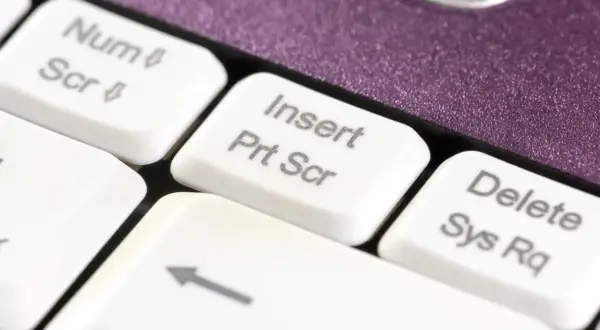 Klawisz "Insert Prt Scr" na białej klawiaturze, gotowy do zrobienia zrzutu ekranu.