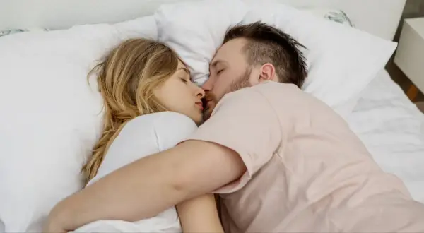 Para młodych ludzi śpi przytulona, ich twarze blisko siebie. Czy to sen, czy może spełnienie erotycznych marzeń?