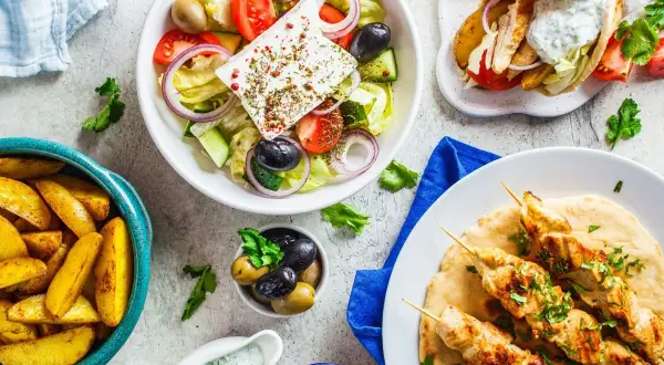 Pyszny grecki posiłek: sałatka grecka, gyros, frytki i hummus. Idealny na letni wieczór z przyjaciółmi.
