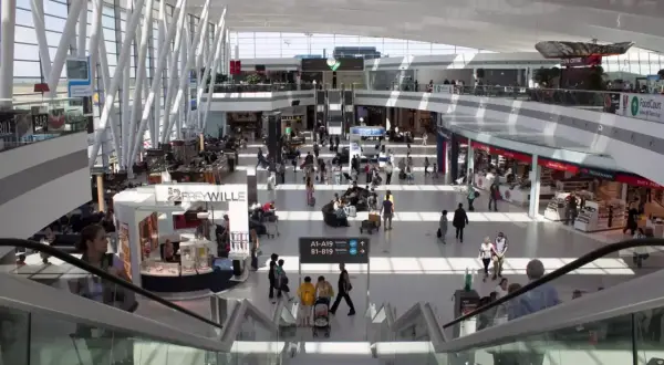 Tętniący życiem terminal lotniska w Budapeszcie. Ludzie przemieszczają się między sklepami i restauracjami, czekając na swoje loty.