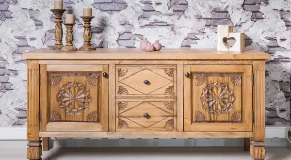 Buffet en bois sculpté, prêt à recevoir une nouvelle teinte. Ses portes ornées de motifs étoilés et ses tiroirs invitent à le teindre un meuble en bois déjà teint pour un relooking.