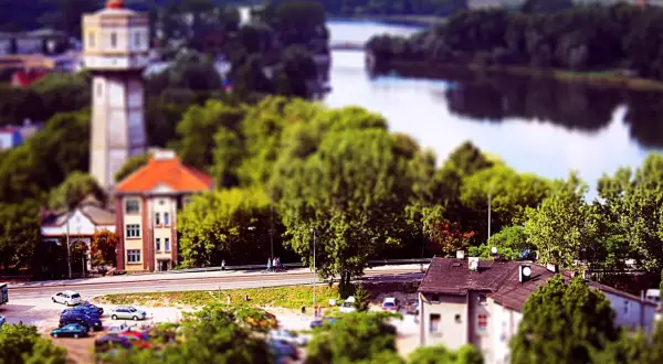 Widok na wieżę ciśnień, budynki i rzekę w Kruszwicy.