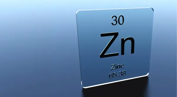 Plaque bleue avec le symbole chimique Zn, numéro atomique 30. Le zinc est essentiel pour la peau, aidant à réduire les rides.