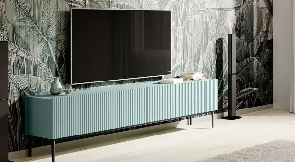 Elegancka szafka RTV z telewizorem na ścianie, idealna do wnętrz z motywem roślinnym. Dowiedz się, jak ukryć kable od telewizora na ścianie bez kucia.