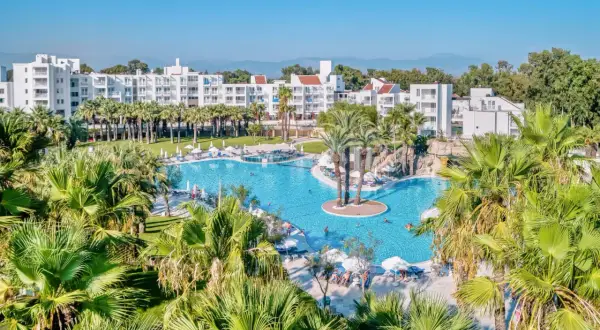 Rodzinny resort Monachus Family Resort Sorgun z basenem i palmami.