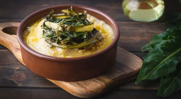 Polenta cremosa con cicoria in padella, un piatto rustico e saporito.