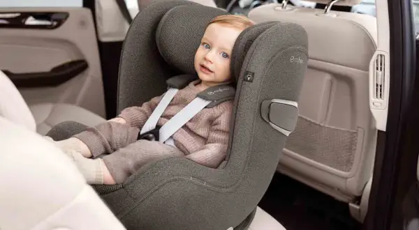 Kleines Kind im Kindersitz, das sich auf die Frage konzentriert: ab wann darf Baby in Fahrtrichtung sitzen?