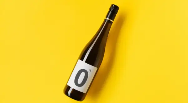 Bottiglia di vino dealcolato con etichetta "0" su sfondo giallo brillante.