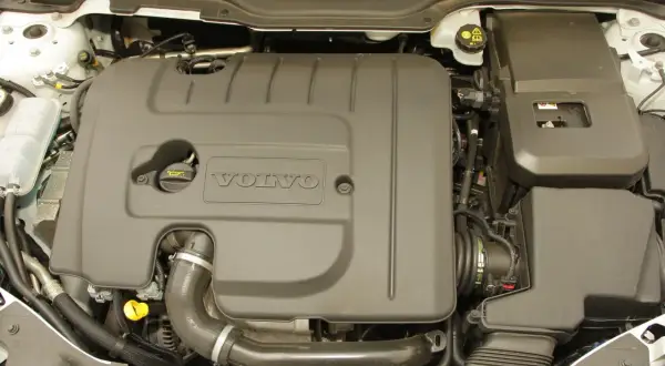 Silnik Volvo V50 1.6 diesel. Widoczna osłona silnika z logo Volvo, przewody i elementy układu dolotowego.