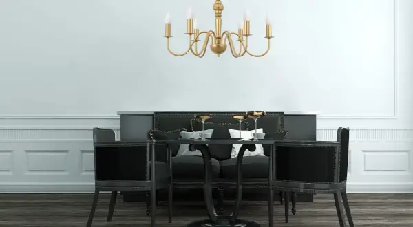 Elegancka, złota lampa zwis nad czarnym stołem z krzesłami. Idealna do wytwornej jadalni.