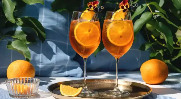 Dwa Aperol Spritz z pomarańczą i kwiatkiem. Idealne na lato, łatwo dowiedzieć się, aperol jak zrobić.