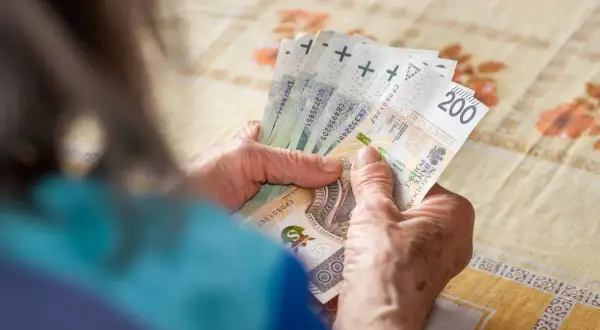 Dłonie liczą banknoty 200 zł. Zastanawiasz się, jaki podatek od emerytury 6000 zł brutto?