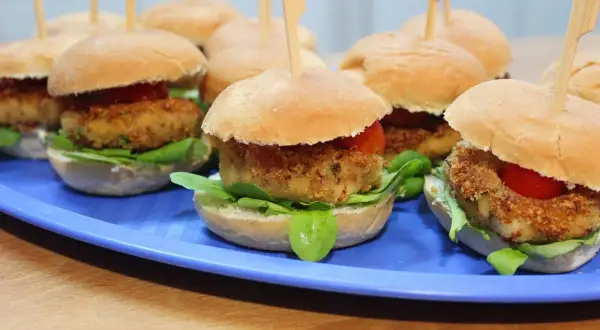 Mini burgery z kotletem w panierce, sałatą i pomidorkiem. Idealne gorące dania na sylwestra w domu.