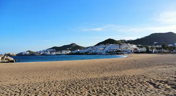Playa de San José, con casas blancas en la ladera y el mar azul. ¡Qué carallo de vista!