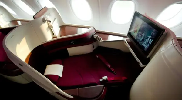 Luxuriöser Sitz im Flugzeug mit Bildschirm, der ein Fußballspiel zeigt. Hier sitzt man bequem, der beste Platz im Flugzeug für eine entspannte Reise.
