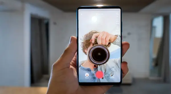 Zrzut ekranu telefonu z aplikacją do nagrywania wideo. Mężczyzna robi sobie selfie z aparatem.