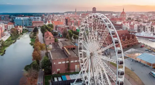 Widok na miasto z diabelskim młynem w Gdańsku. W tle rzeka Motława i zabytkowa zabudowa.