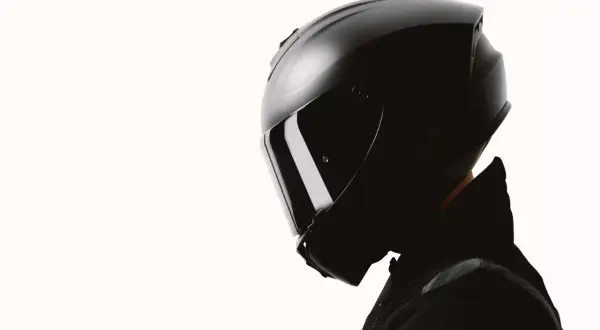 Czarny kask motocyklowy z przyciemnianą szybką. Zastanawiasz się, jaki kask motocyklowy wybrać? Ten model to stylowa i bezpieczna opcja.