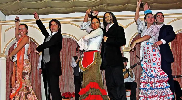 Artistas en escena, aprendiendo flamenco con pasión. Bailarines y músicos crean un espectáculo vibrante.
