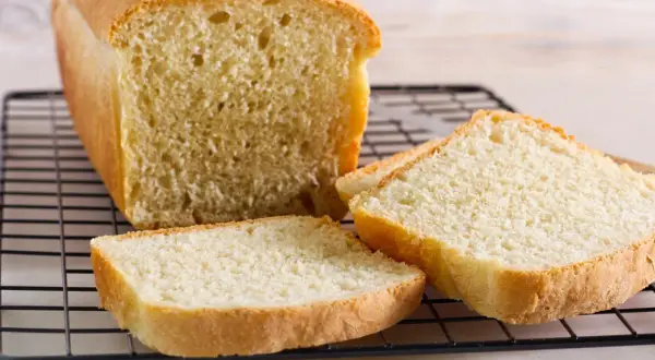 Świeżo upieczony chleb tostowy na kratce, z kilkoma kromkami obok. Idealny na śniadanie, warto sprawdzić chleb tostowy kcal.