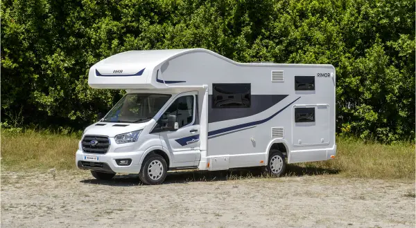 Nowy biały kamper z niebieskimi akcentami, idealny na wakacje. Sprawdź ofertę camper wypozyczenie.