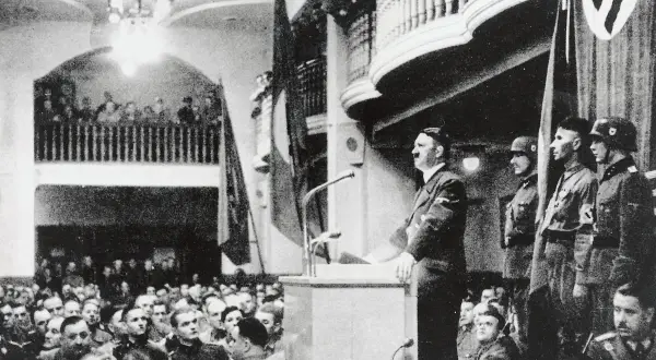 Hitler spricht vor jubelndem Publikum. Ein Attentat auf Hitler 1939 scheiterte. Soldaten stehen Spalier.