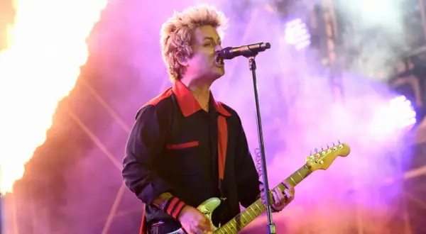 Billie Joe Armstrong von Green Day rockt die Bühne beim Rock am Ring Festival, umgeben von Flammen und lila Licht.