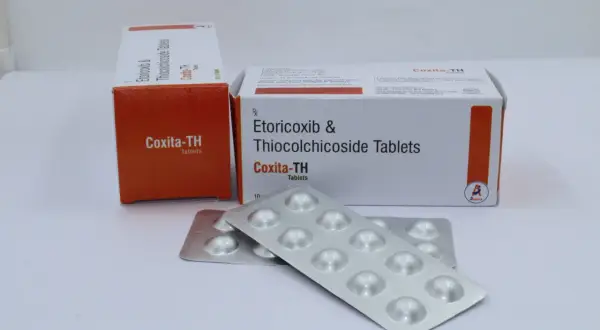 Opakowania leku Coxita-TH i blistry z tabletkami.