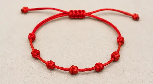 Pulsera roja con siete nudos, cada uno con su propia historia y significado.