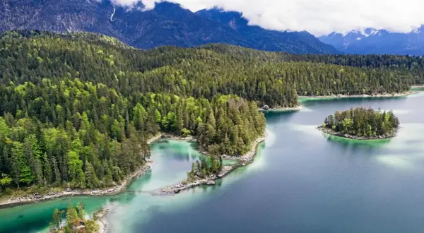 Idyllischer Bergsee mit Inseln, umgeben von dichten Wäldern. Perfekt für einen erfrischenden Tag zum schwimmen.