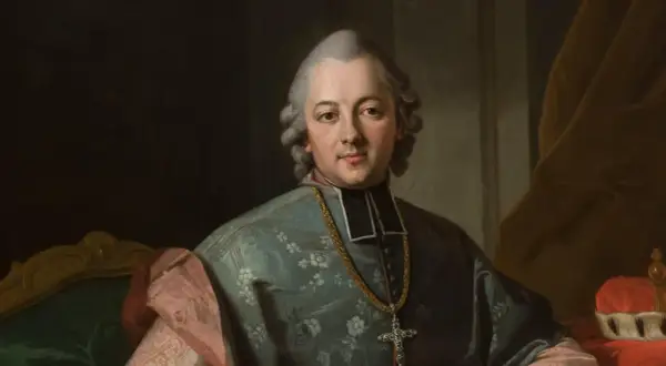 Portret biskupa w stroju duchownym, z łańcuchem i krzyżem. Postać odzwierciedla styl epoki oświecenia, w której tworzył Krasicki.